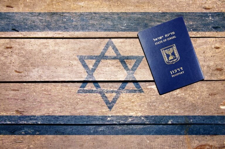 דרכון ישראלי כחול מונח על דגל ישראל מודפס על לוחי עץ